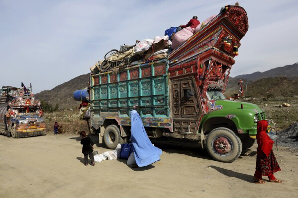 FILE - An Afghan refugee family return to Afghanistan through Pakistan's border crossing, Torkham, east of Kabul, Afghanistan, on Wednesday, March 11, 2015. Pakistan's caretaker Interior Minister on Tuesday, Oct. 3, 2023, asked all illegal immigrants, including Afghans, to go back to their countries voluntarily before October 30 to avoid mass arrest and forced deportation, sending a wave of panic, especially among 1.7 million Afghan refugees living in the Islamic nation without valid documents. (AP Photo/Rahmat Gul, File)