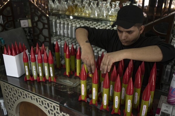 Belal Abu Saraya arranges perfume containers representing rockets used against Israel in a perfume store against Israel in past conflicts at his shop in Gaza City on Thursday, Oct. 5, 2023. AP Photo/Fatima Shbair)