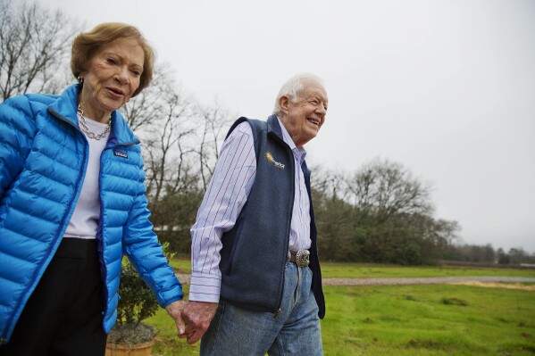 FILE - In this Feb. 8, 2017, photo, former President Jimmy Carter, right, and his wife Rosalynn arrive for a ribbon cutting ceremony for a solar panel project on farmland he owns in their hometown of Plains, Ga. Jimmy and Rosalynn are celebrating their 77th wedding anniversary, Friday, July 7, 2023. (AP Photo/David Goldman, File)