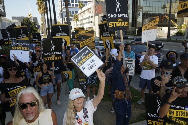 Actor and SAG-AFTRA negotiator Frances Fisher, middle, raises her sign on a picket line outside Netflix studios on Tuesday, Sep. 26, 2023, in Los Angeles. (AP Photo/Damian Dovarganes)