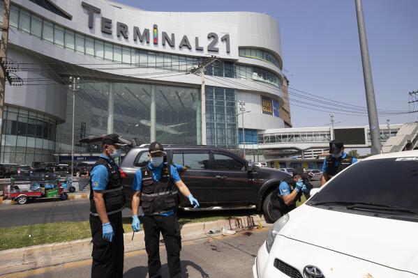 Forensic officers inspect a shooting scene outside the Terminal 21 Korat mall in Nakhon Ratchasima, Thailand, Sunday, Feb. 9, 2020. Thai officials say a soldier who went on a shooting rampage and killed numerous people and injured dozens of others has been shot dead inside the mall in northeastern Thailand. (AP Photo/Wason Wanichakorn)
