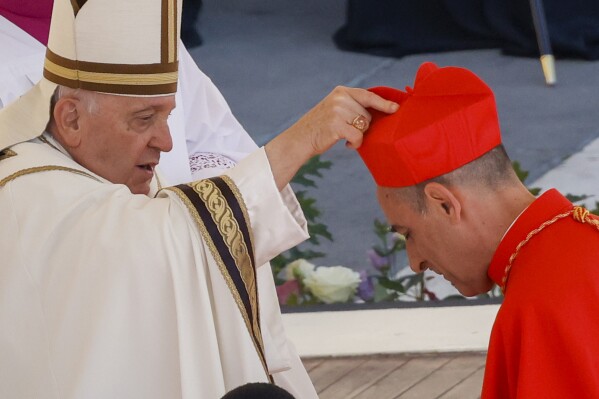 Newly elected Cardinal Víctor Manuel Fernández, Prefect of the Dicastery for the Doctrine of the Faith, right, receives his biretta from Pope Francis as he is elevated in St. Peter's Square at The Vatican, Saturday, Sept. 30, 2023. (AP Photo/Riccardo De Luca)